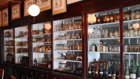 Cabinets in an old pharmacy full of pharmaceutical bottles. 