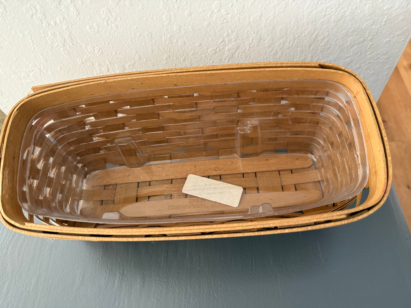 Wicker basket with a clear plastic liner on a gray surface
