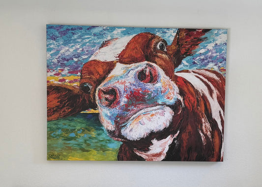 Colorful painting of a cow's face on a white wall