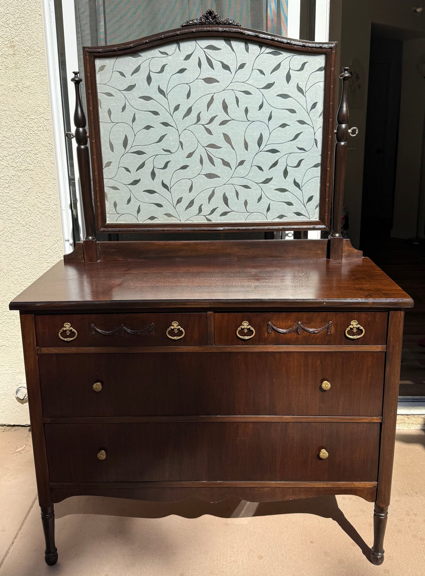 Wooden cabinet with decorative glass panel on a neutral background