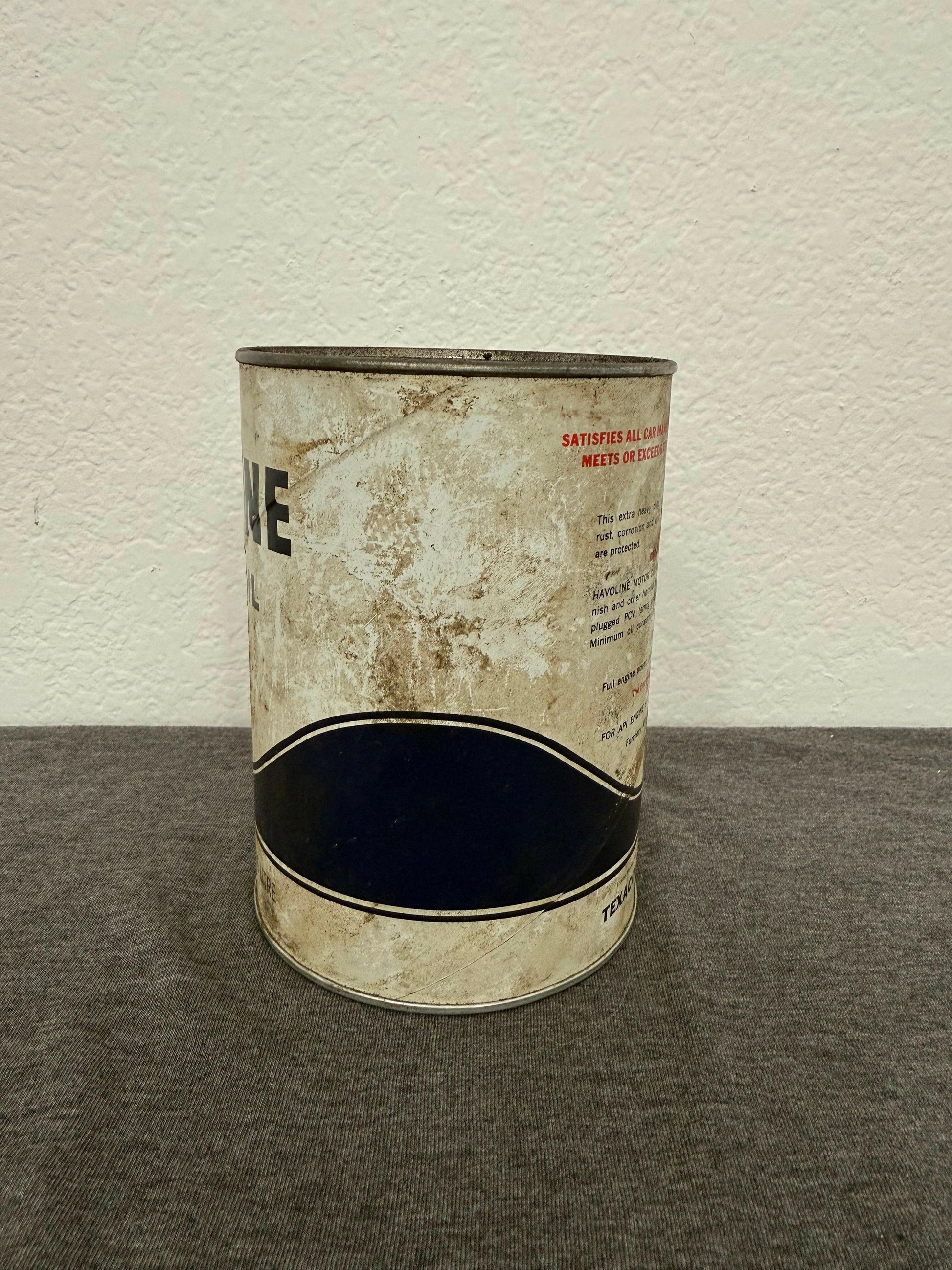 Worn metal can with visible text on a white and gray background