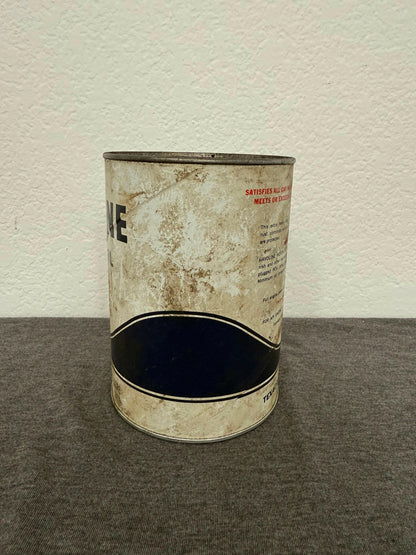 Worn metal can with visible text on a white and gray background