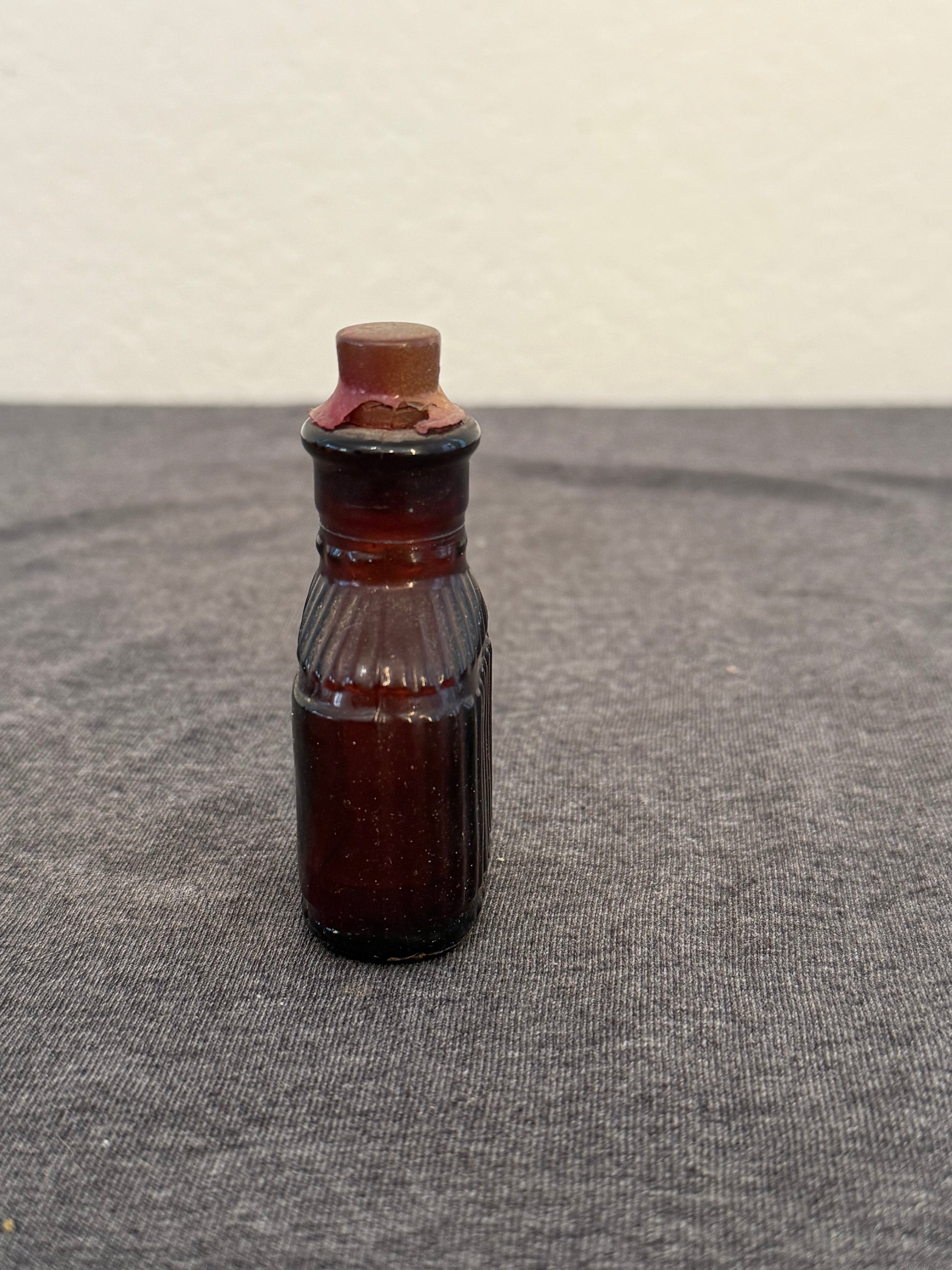 Small brown bottle on a textured gray surface