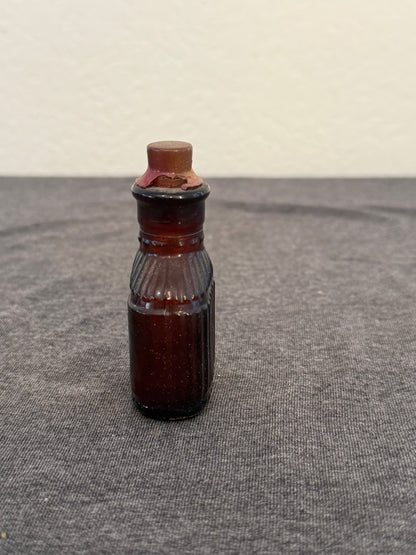 Small brown bottle on a textured gray surface