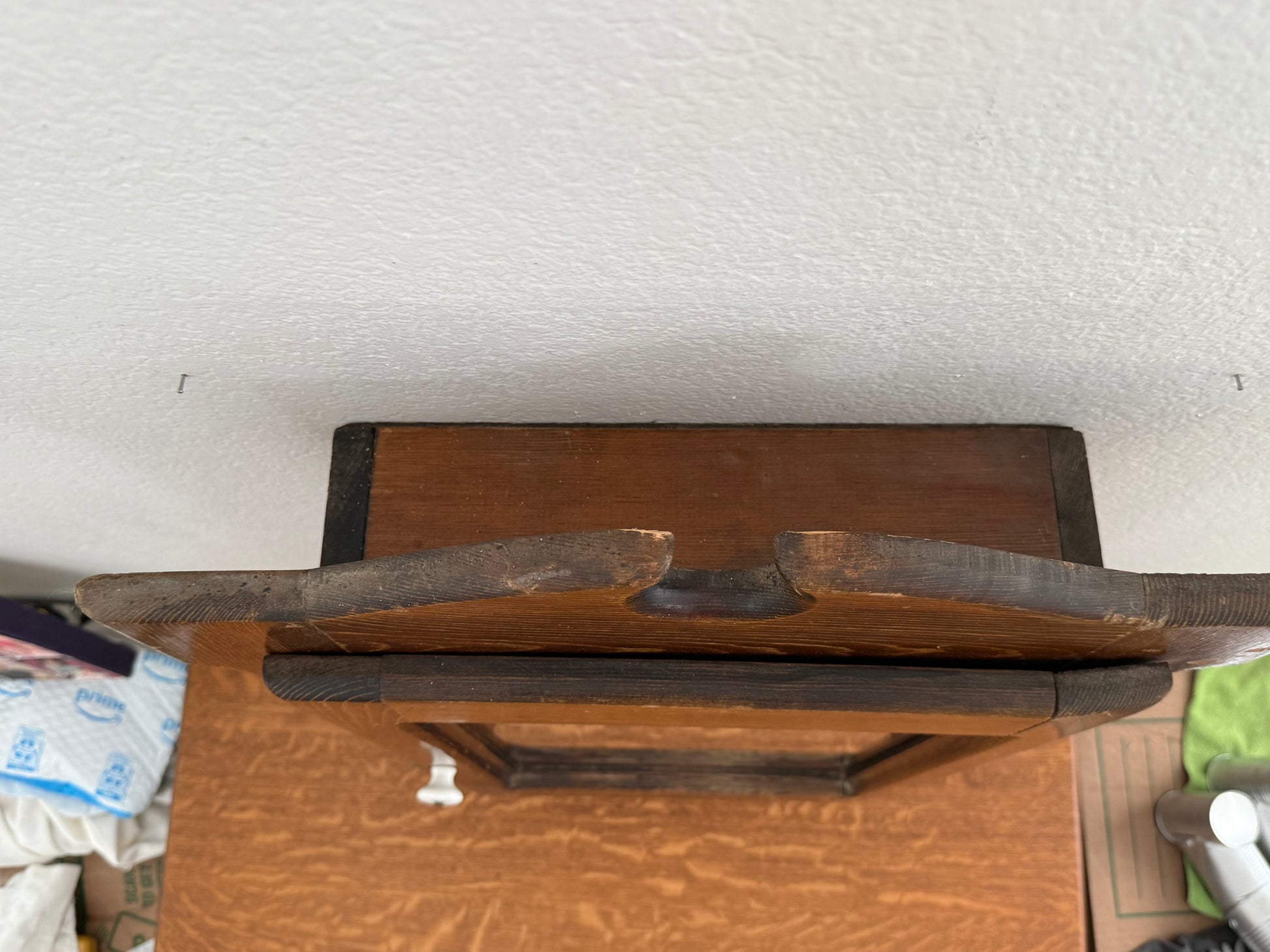 Wooden cabinet with a textured white wall in the background