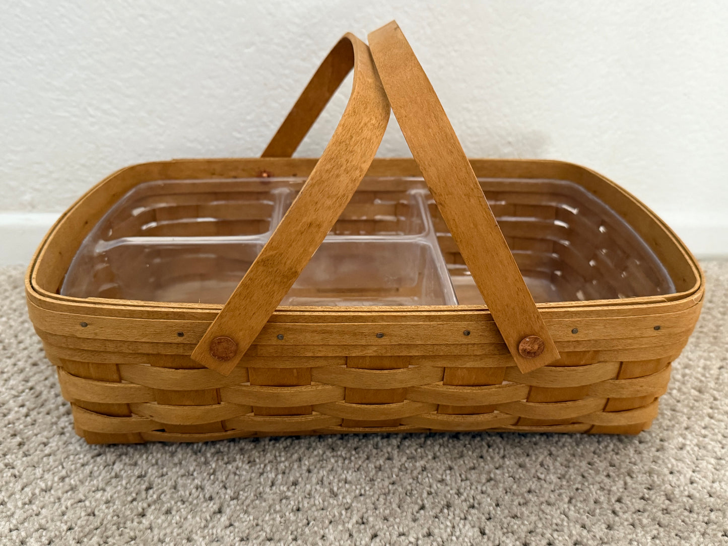 Wooden picnic basket with a clear lid on a textured surface