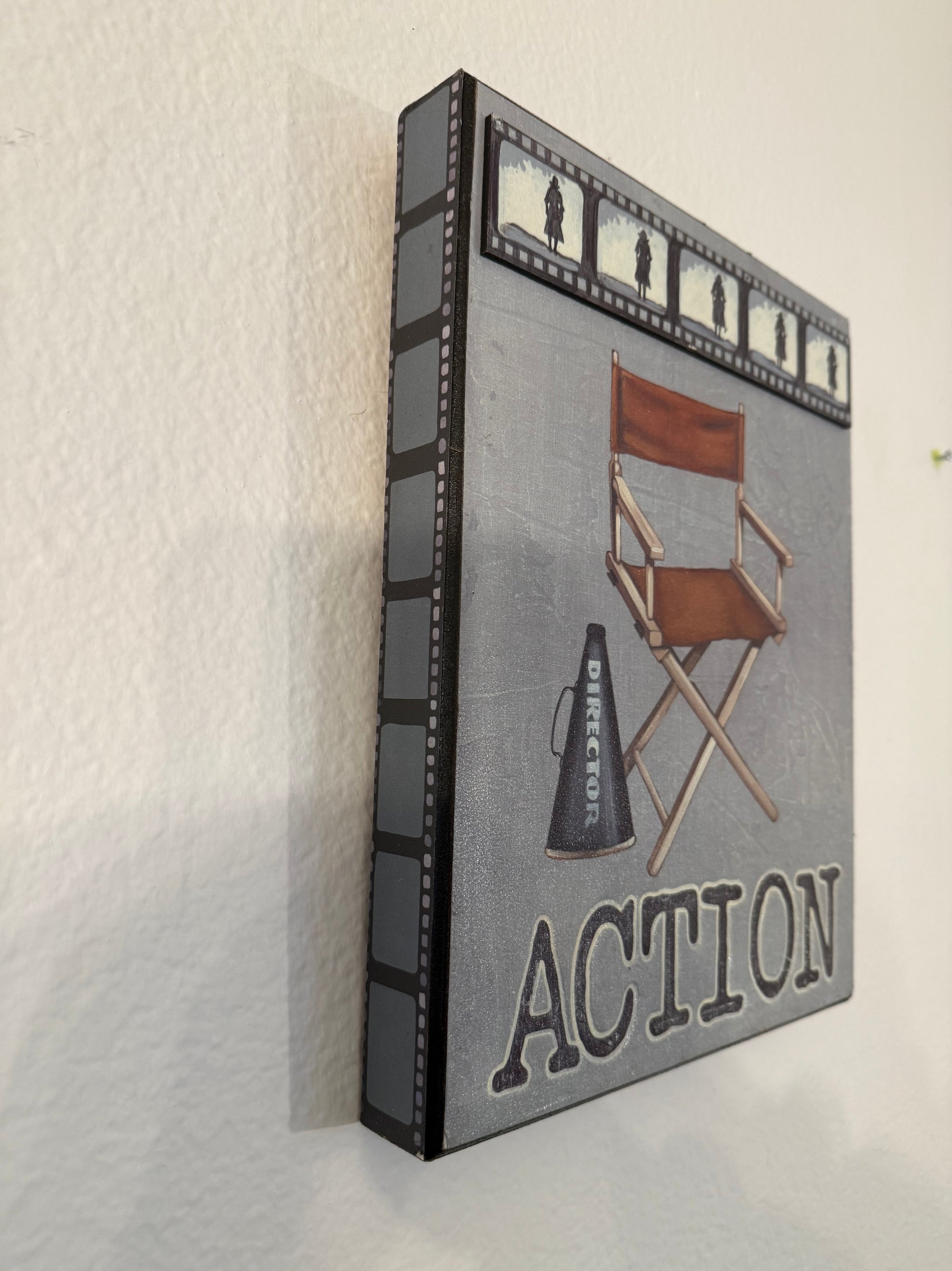 Decorative box with film reel design and 'Action' text on a white background