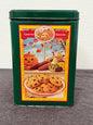 Green cookie tin with colorful label featuring a pie and autumn-themed design on a gray background.