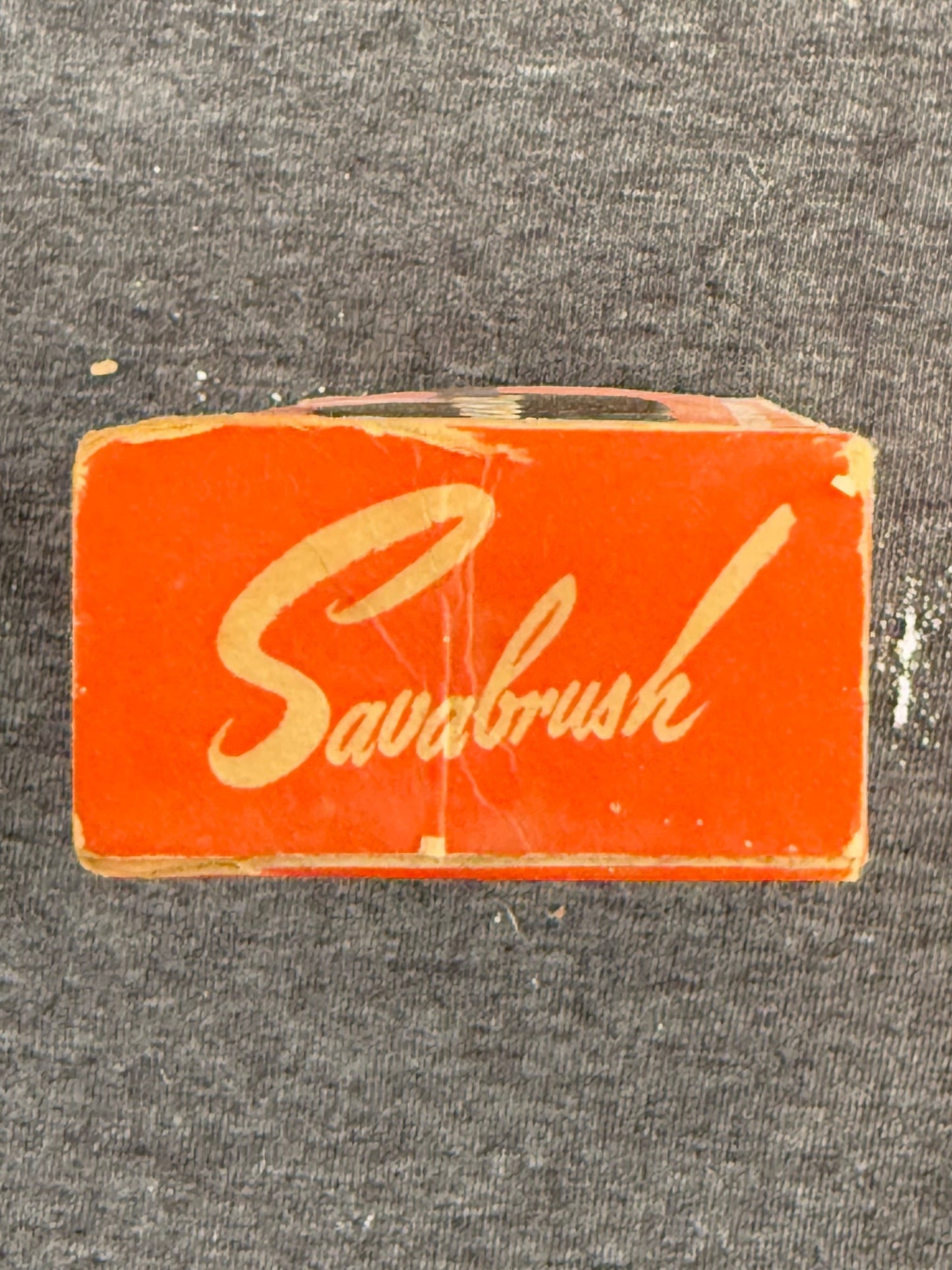 Small red box with 'Savabrush' branding on a gray background