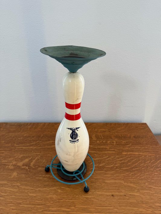 Vintage-style bowling pin with red and blue stripes on a white background