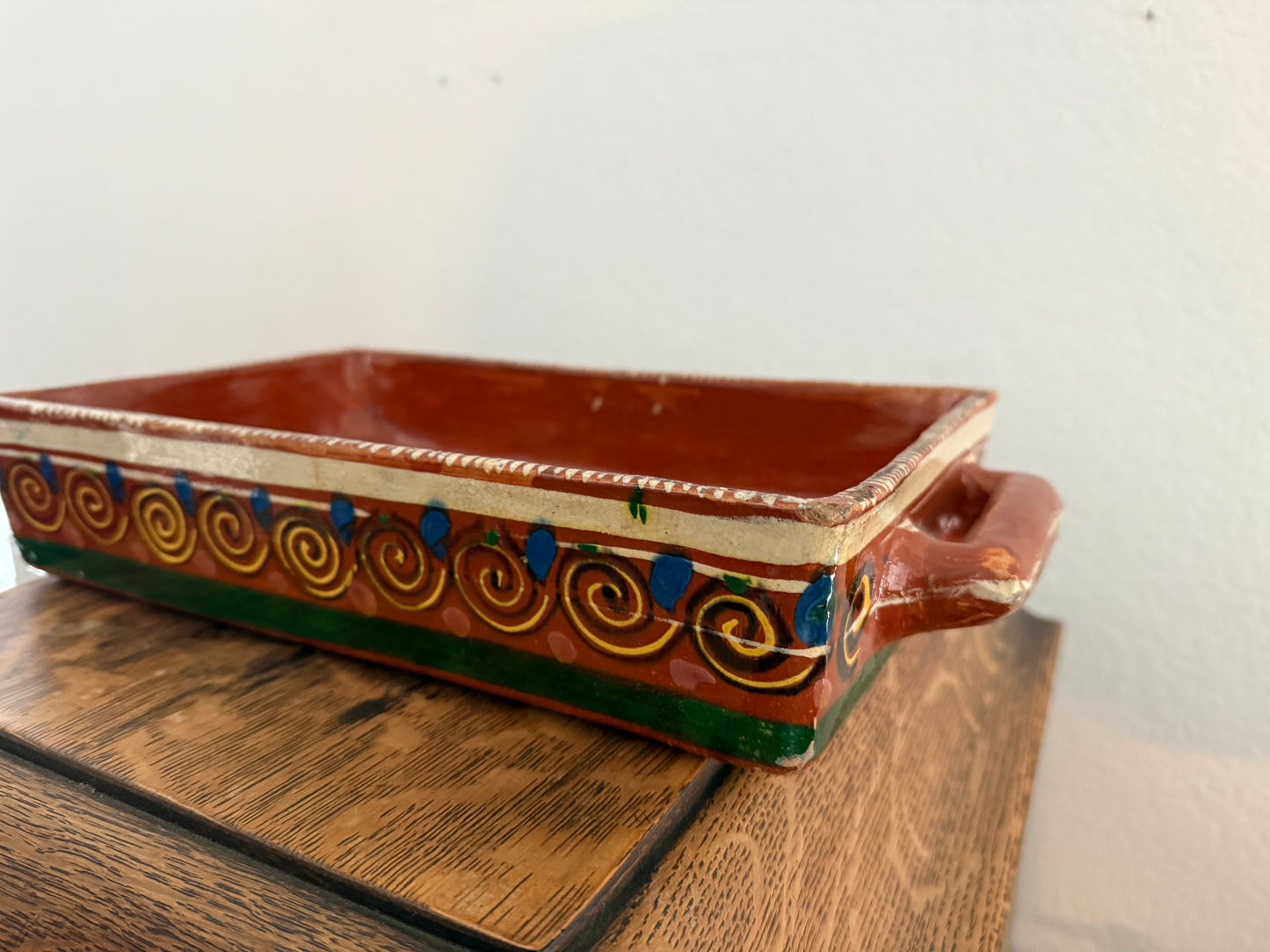 Decorative ceramic tray with spiral patterns on a wooden surface