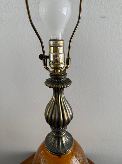 Close-up of a lamp with a decorative metal fitting and light bulb on a plain background