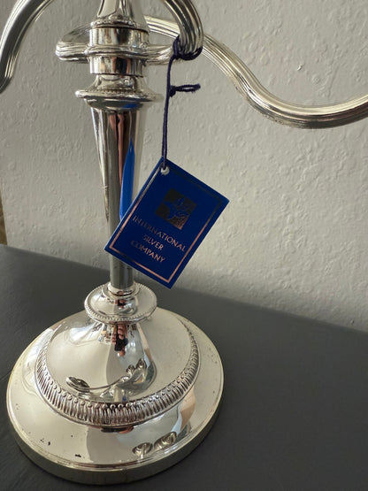 Silver candle holder with a blue tag on a gray background