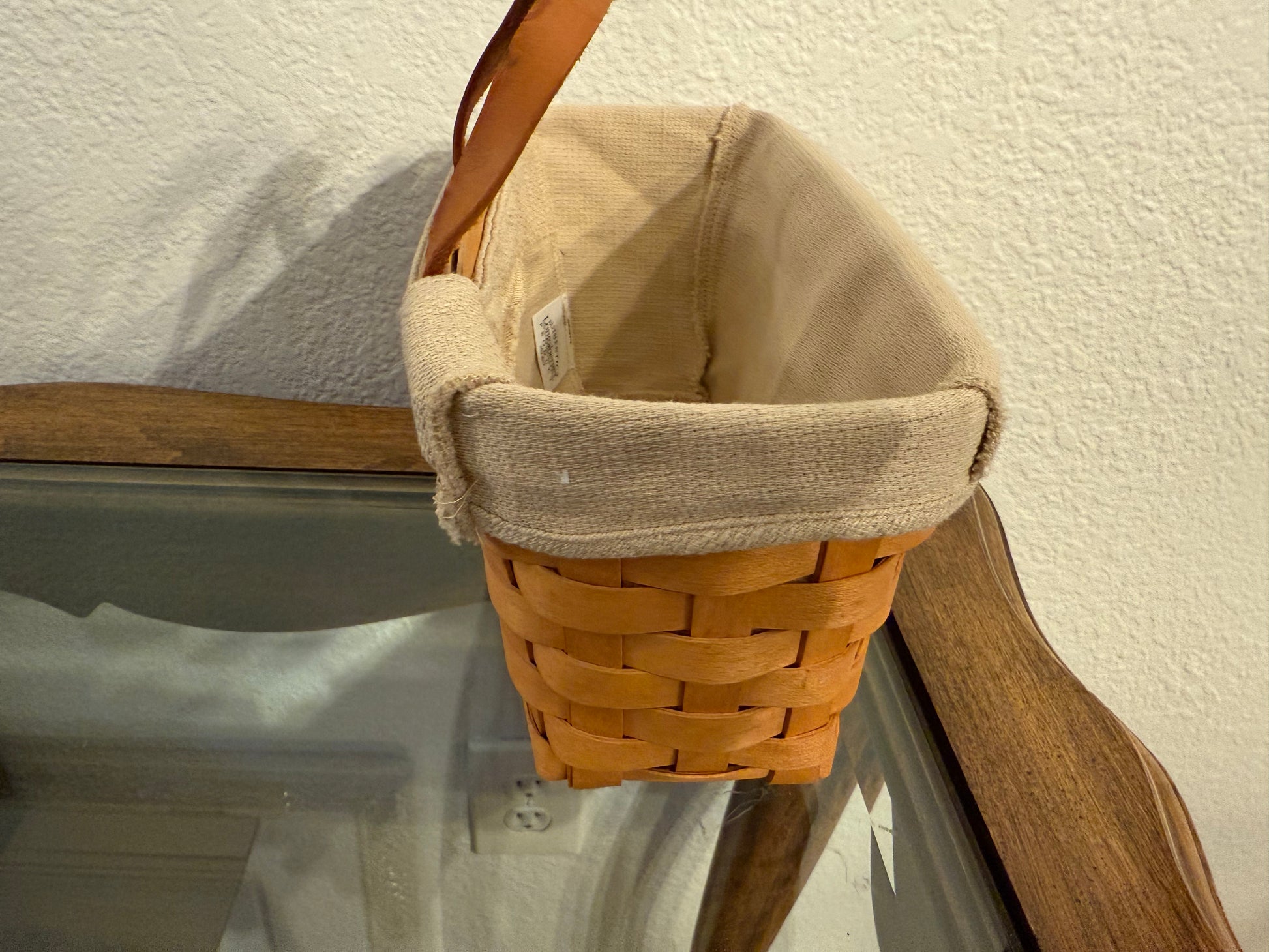 Woven basket with a beige fabric liner on a wooden surface