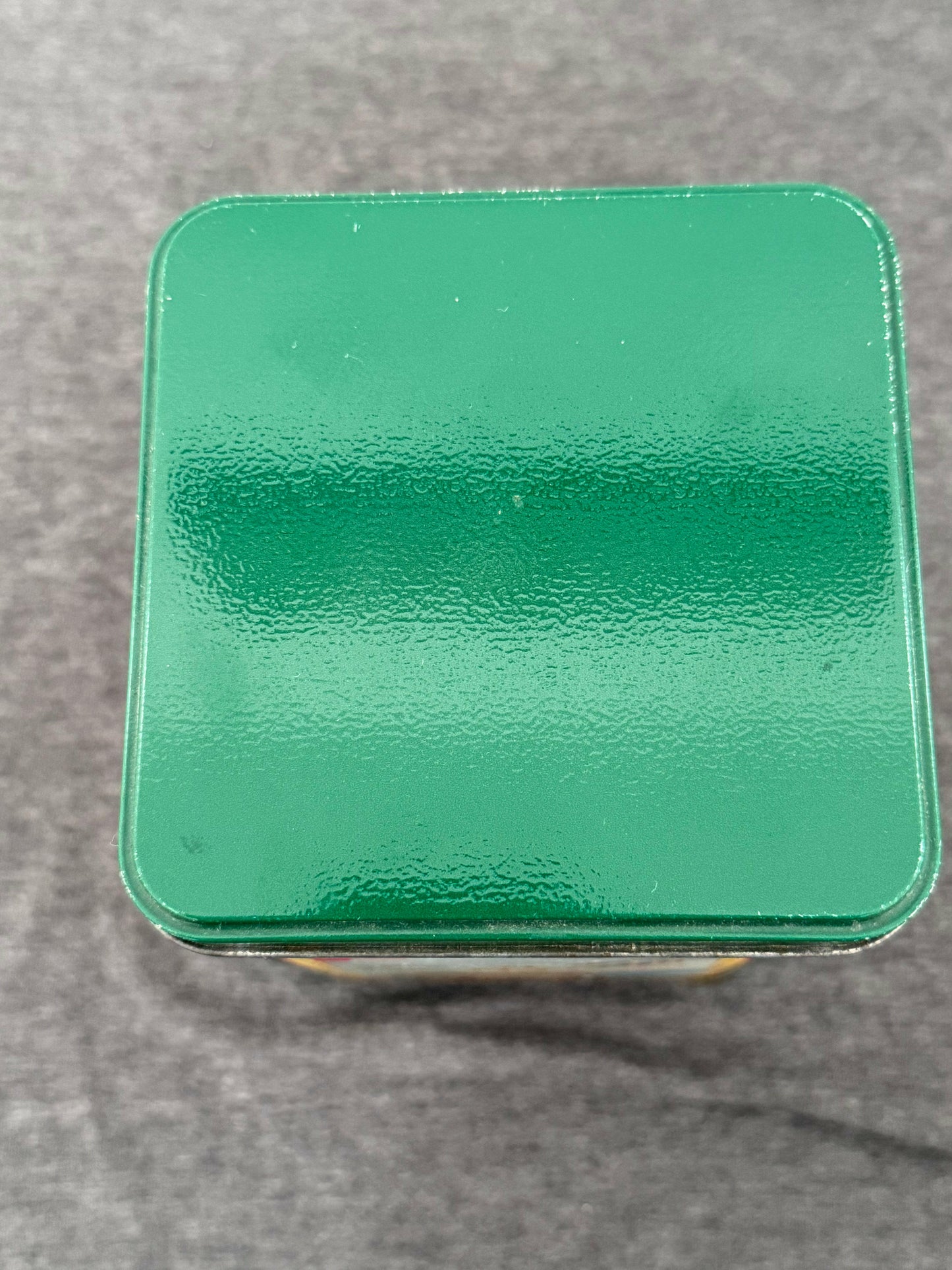 Green metallic square object on a gray background