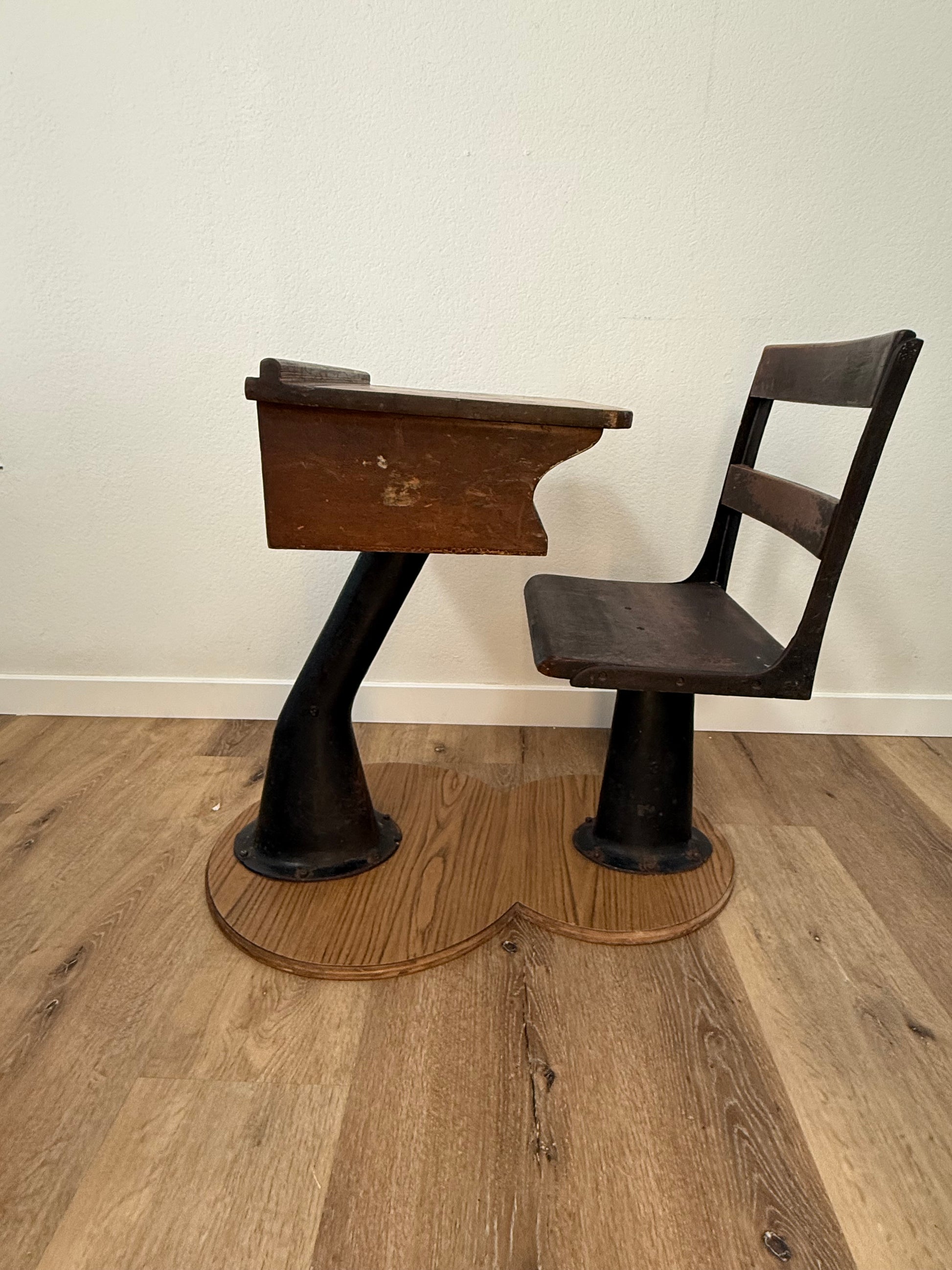 Antique wood school desk with cast iron legs on wooden base