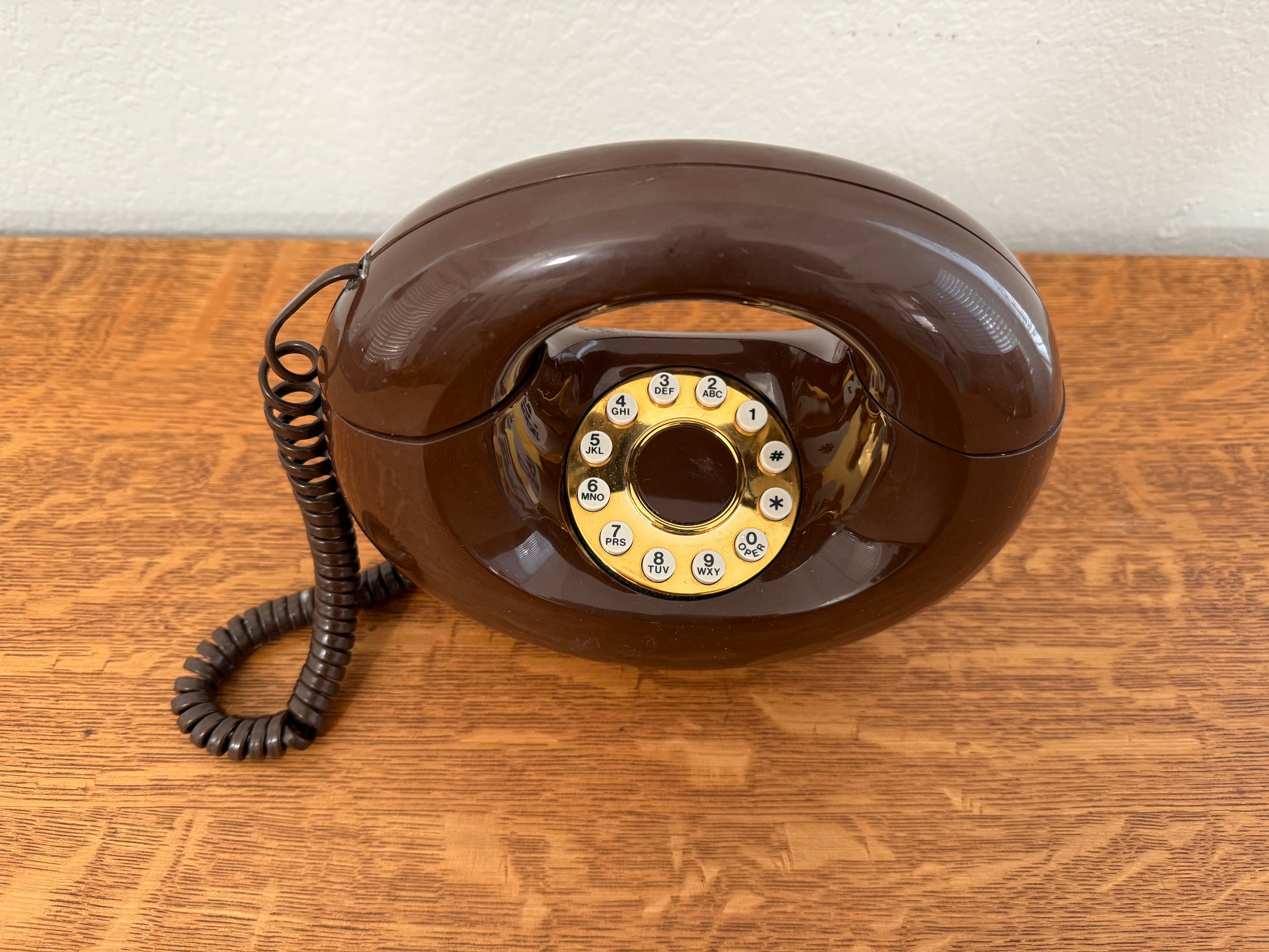 Vintage brown rotary phone on a wooden surface