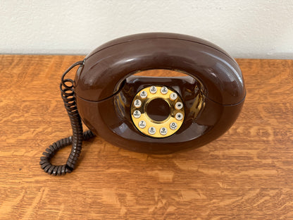Vintage brown rotary phone on a wooden surface