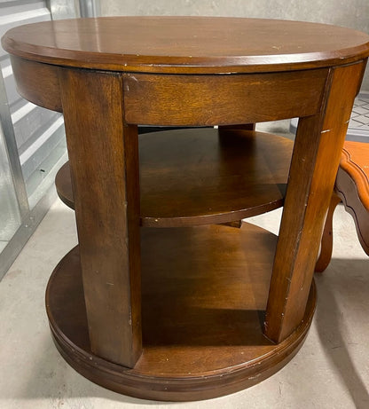 Wooden round table with shelves on a neutral background