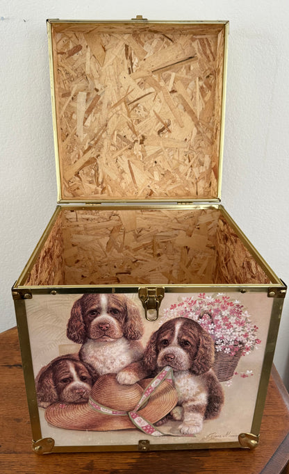 Wooden chest with decorative design of puppies and flowers on a wooden surface.