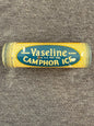 Vintage Vaseline Camphor Ice tube on a textured gray background