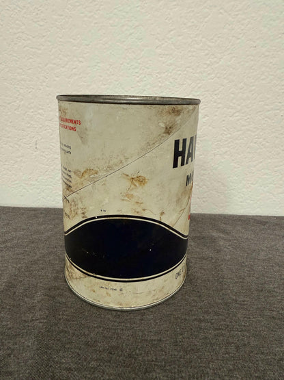 Dented metal can with visible wear on a textured surface
