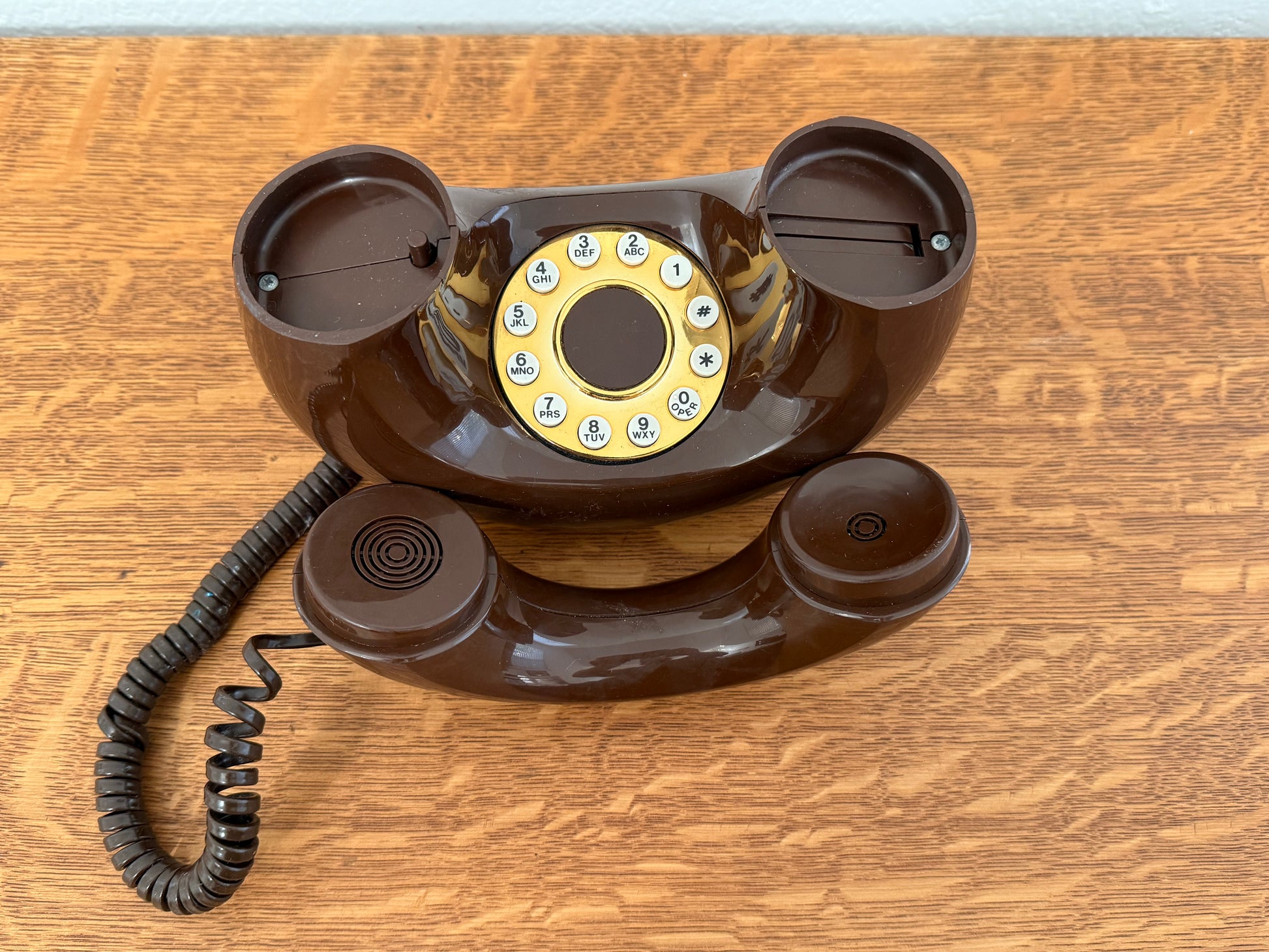 Brown rotary phone on a wooden surface