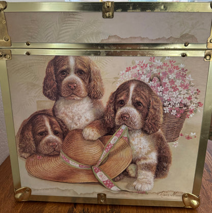 Decorative box with a design of three puppies and a hat on a floral background.