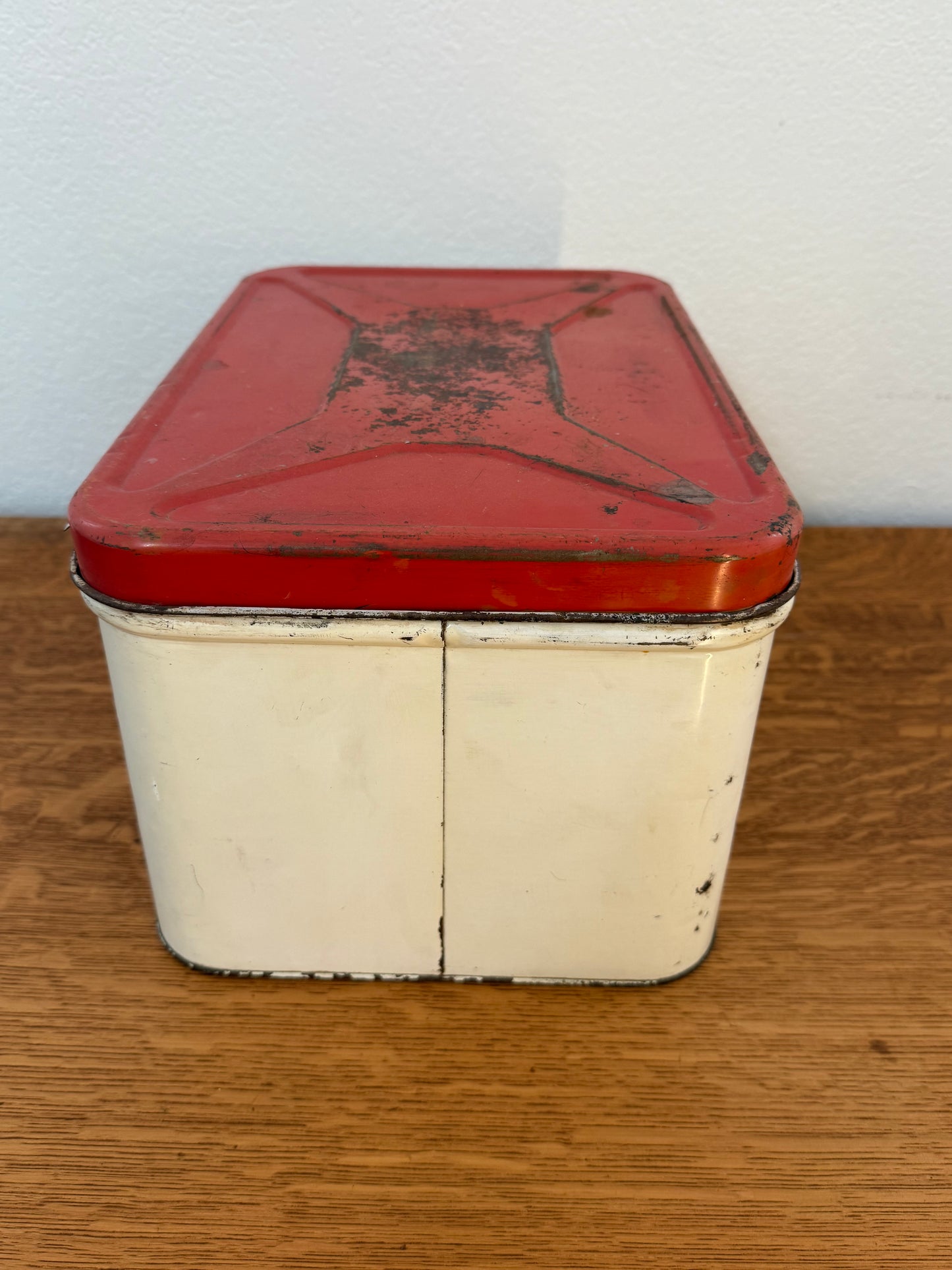 Red and white vintage tin box on a wooden surface
