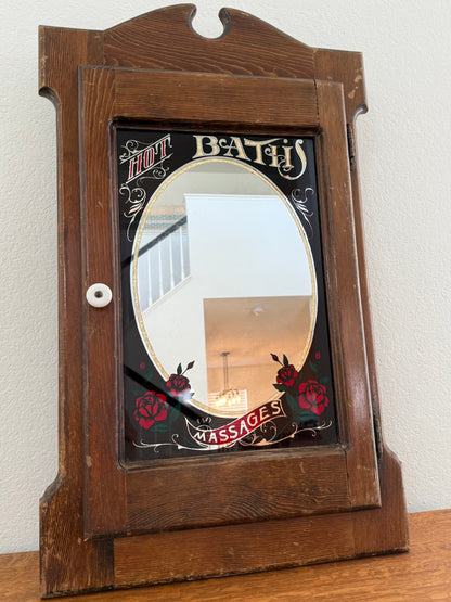 Wooden cabinet with decorative mirror on a white wall