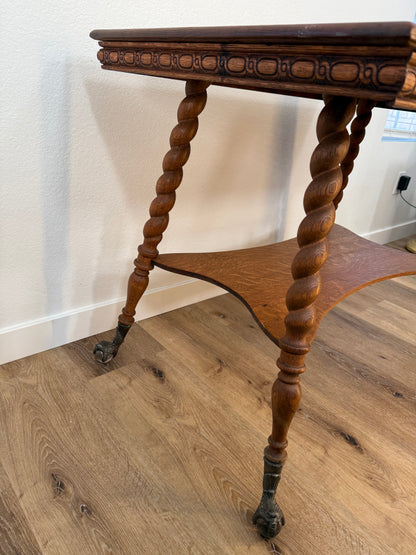 Close-up of a wooden table with twisted legs on a wooden floor.