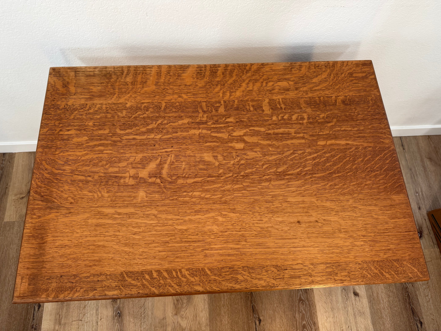 Wooden table with a wavy grain pattern on a wooden floor.