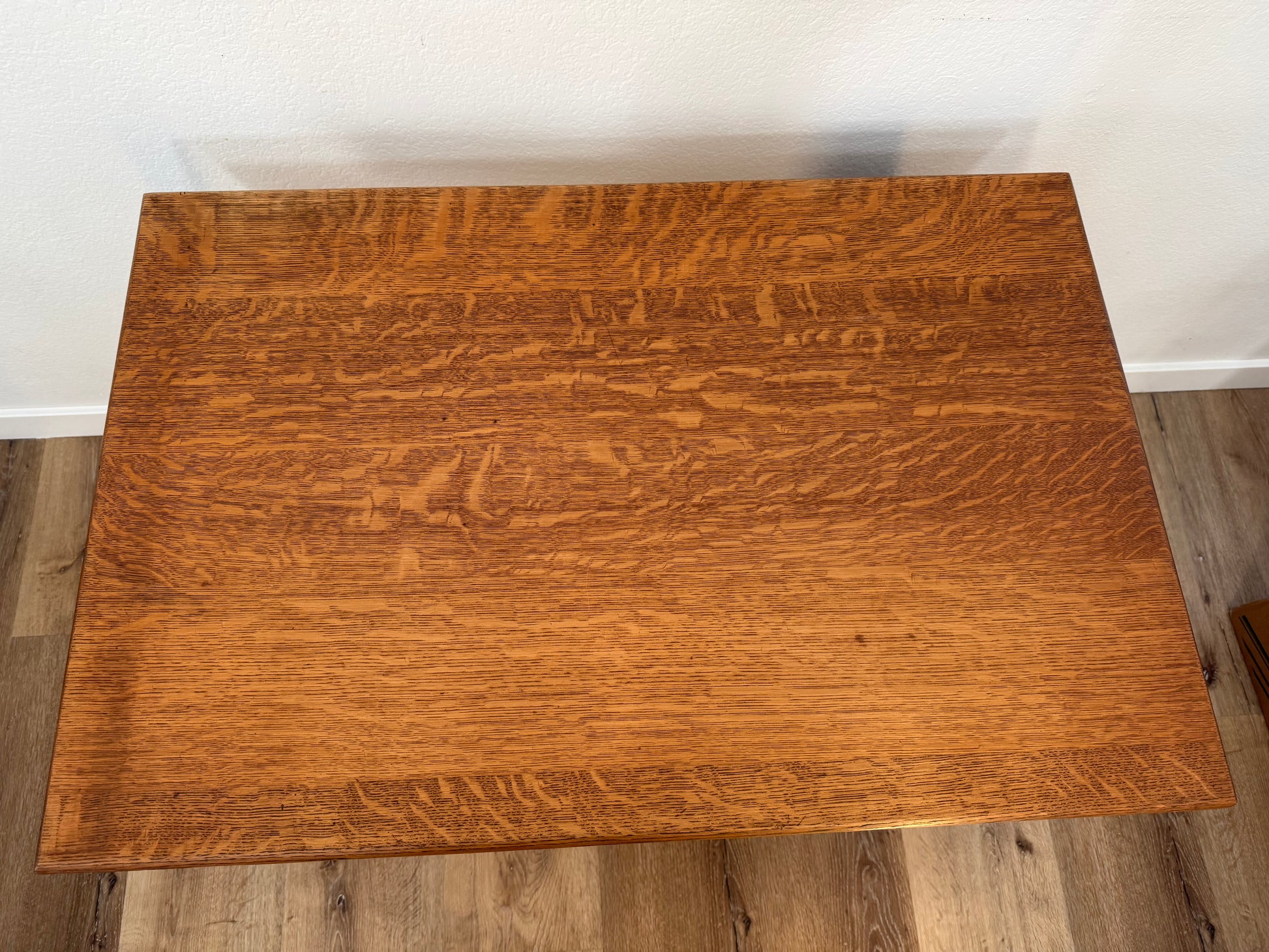 Wooden table with a wavy grain pattern on a wooden floor.