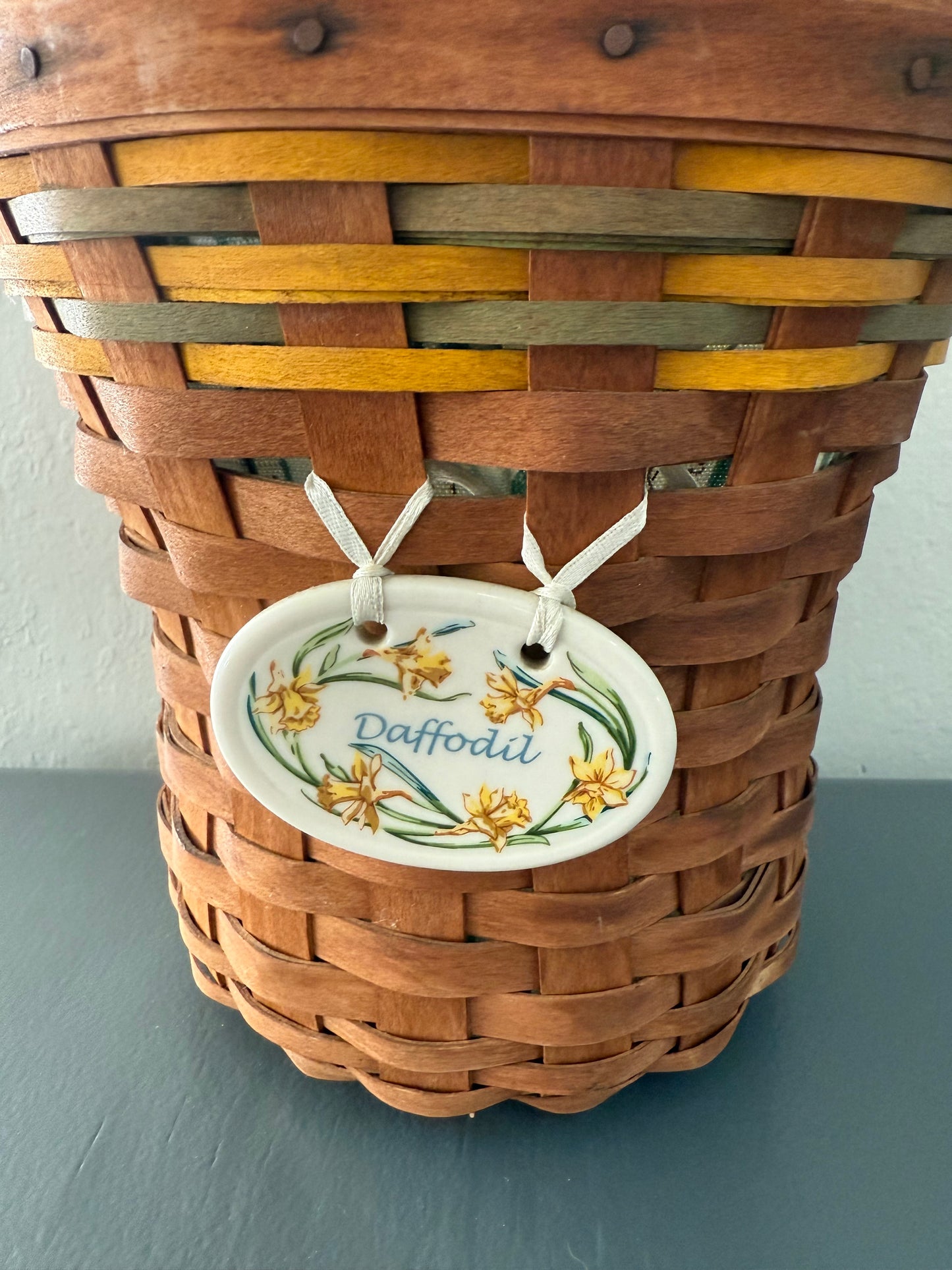 Woven basket with a decorative tag on a plain background