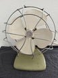 Vintage-style desk fan with white blades and metal frame against a neutral background