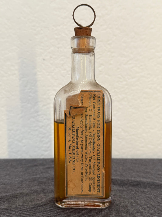Vintage glass bottle with a label on a textured surface