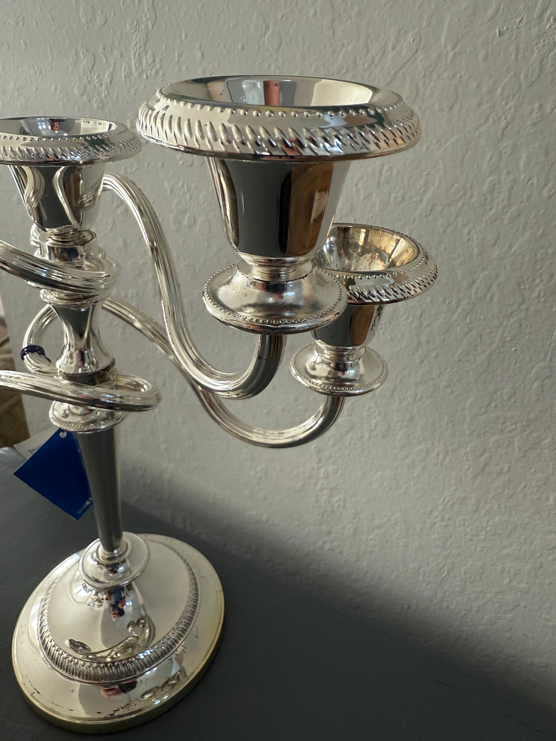 Silver candlestick holder against a plain wall