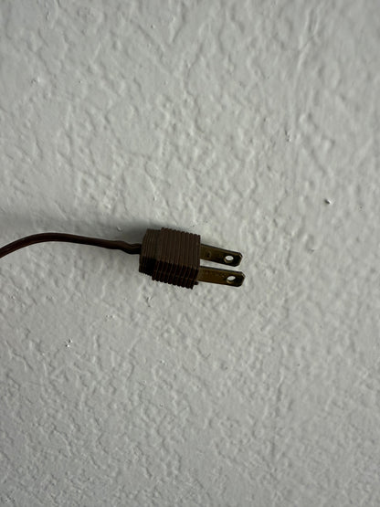 Old-style electrical plug on a textured white surface