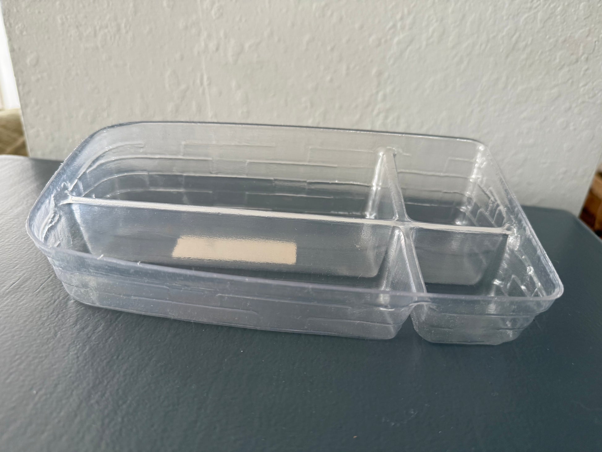 Clear plastic container with a lid on a gray surface