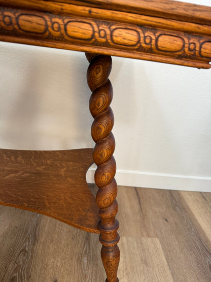 Wooden table with intricate carvings on a wooden floor.