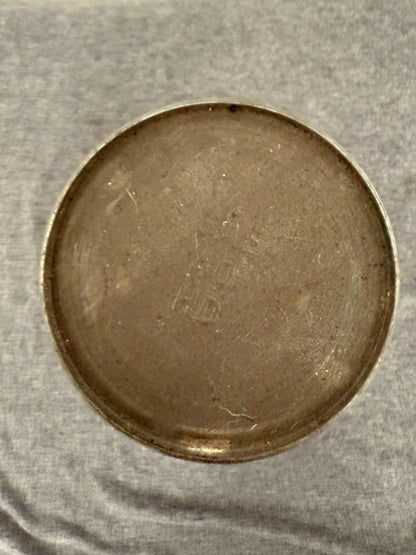 Close-up of the top of oil can on a textured gray background