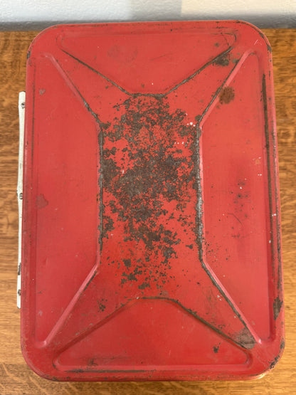 Rust-covered red metal lid on a wooden surface