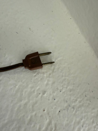 Brown electrical plug on a textured white surface