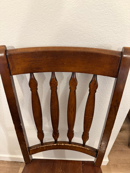 Wooden chair backrest against a white wall