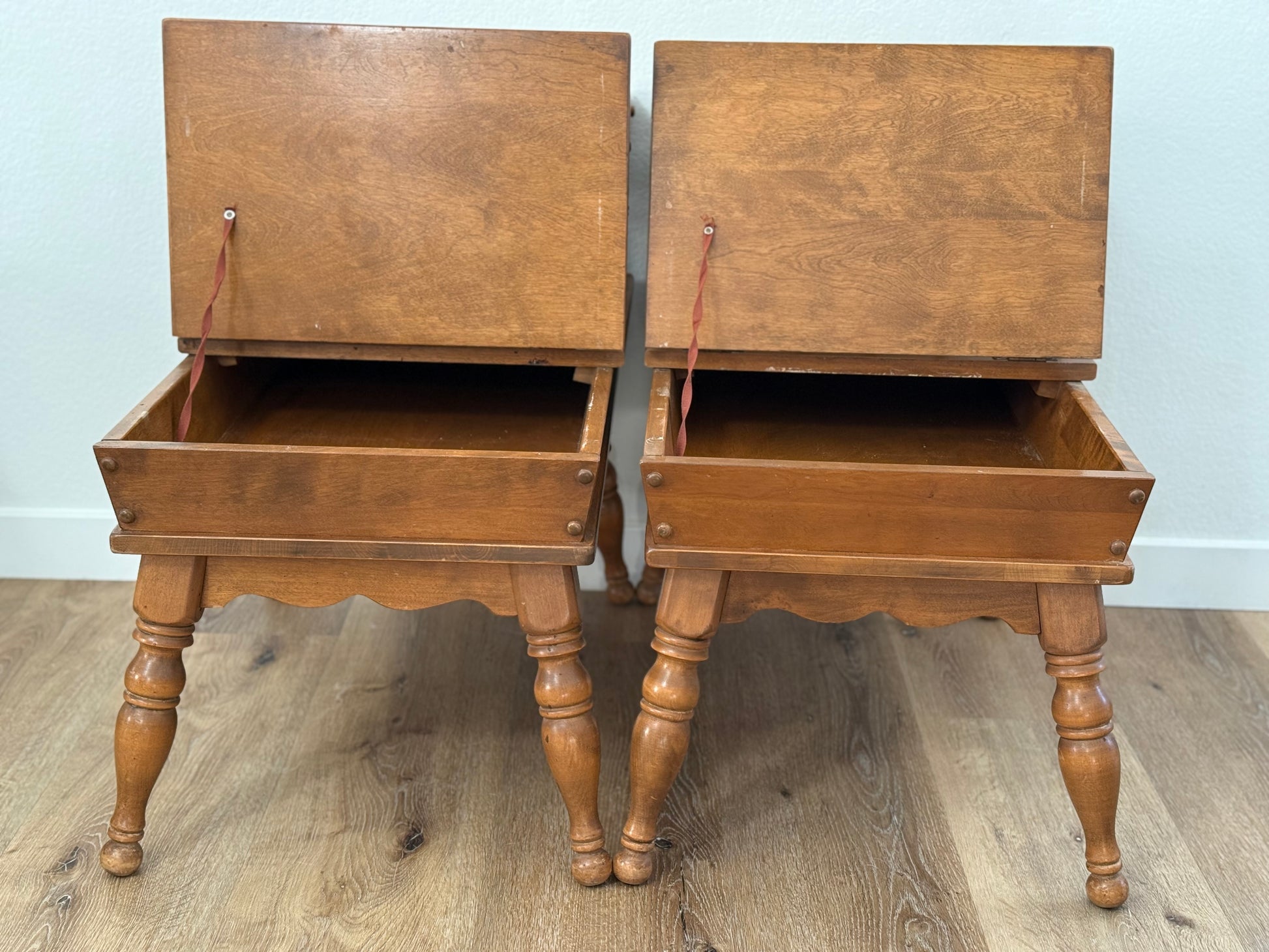 Pair of wooden side tables with open tops on a wooden floor.
