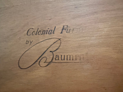 Wooden surface with 'Colonial by Baumm' engraved text