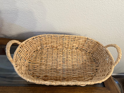 Wicker basket with handles on a wooden surface