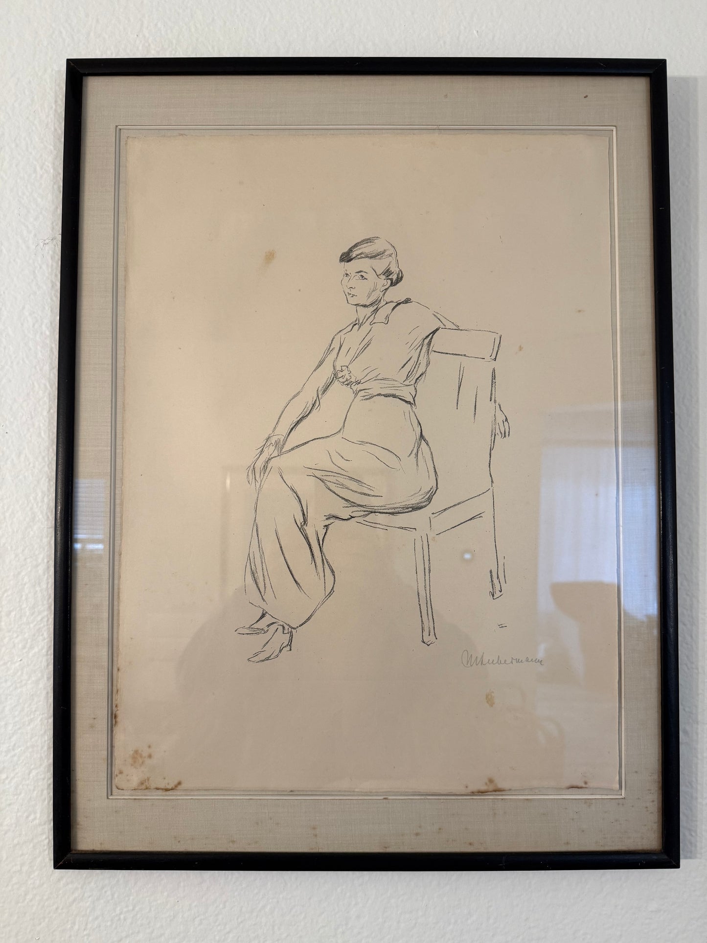 Framed black and white line drawing of a person on a white wall