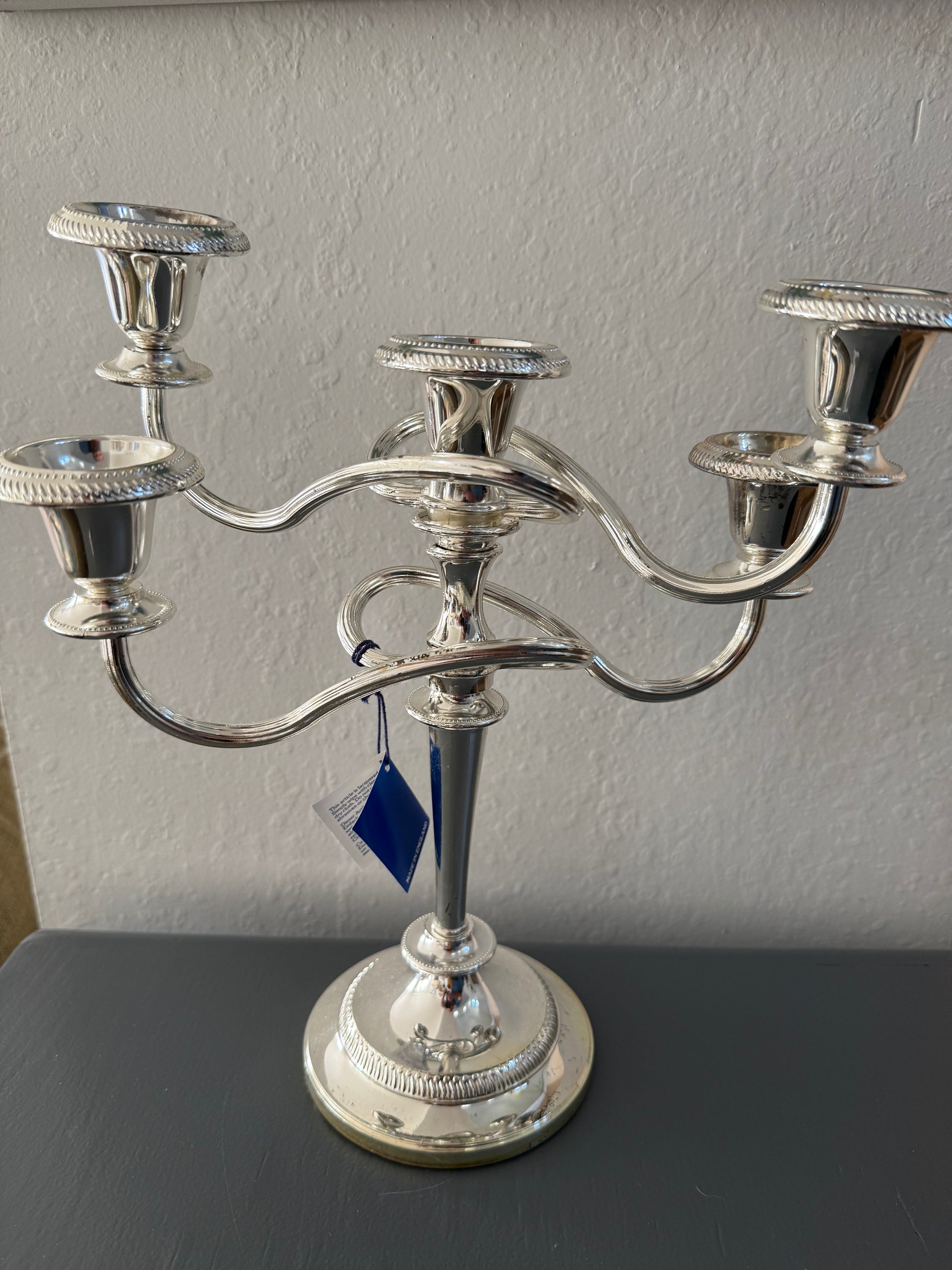 Silver candelabra with 5 candle holders on a gray background
