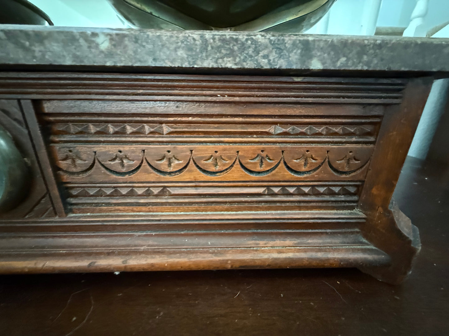 Wooden decorative panel with intricate carvings on a dark surface
